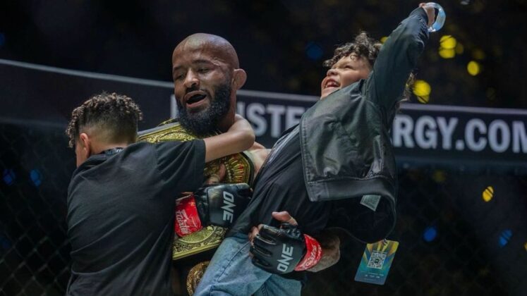 Demetrious Johnson holding his children alongside ONE championship